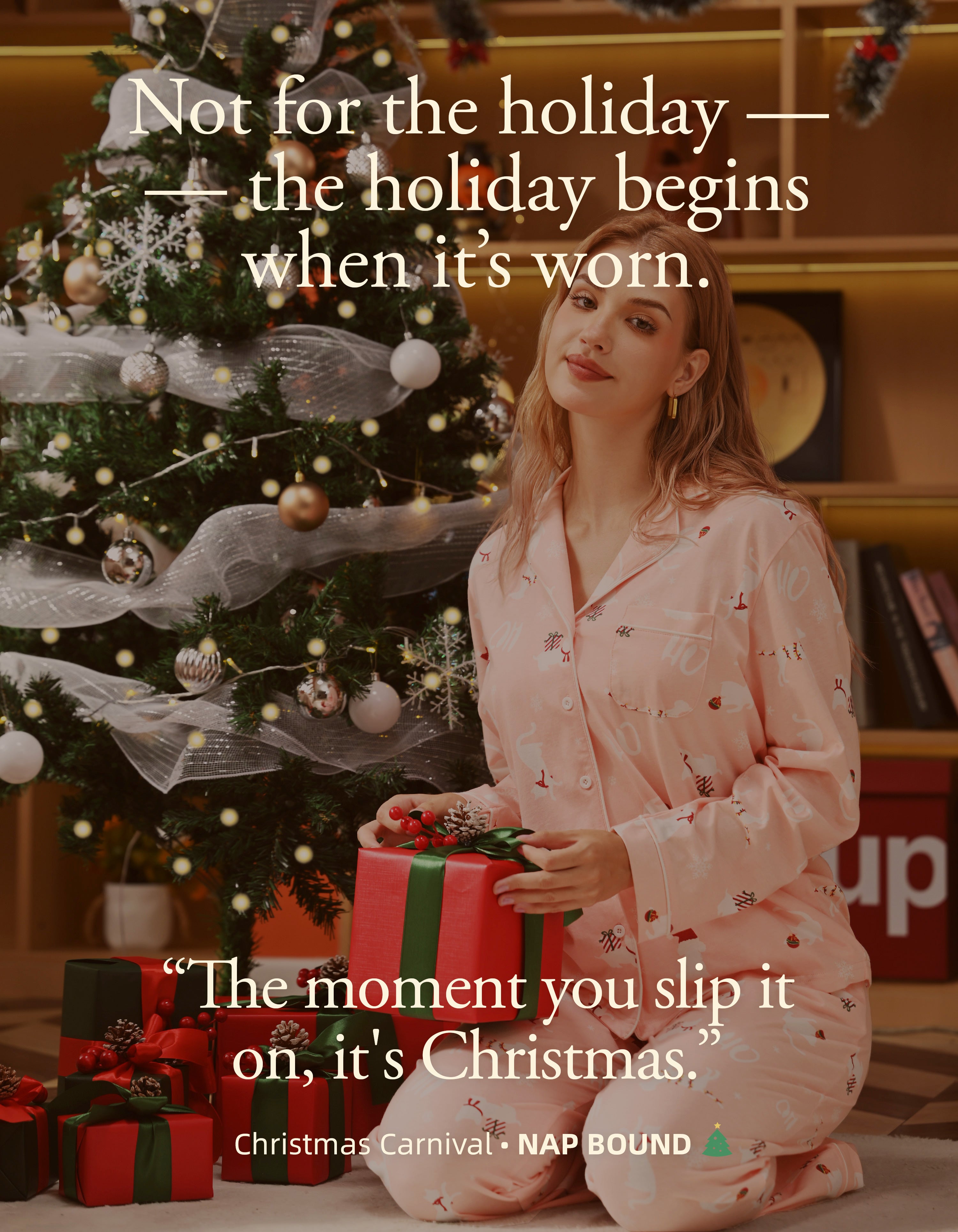 Woman wearing pink Christmas knit cotton pajamas holding gift beside Christmas tree