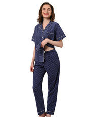Women wearing navy polka dot cotton pajama set with short sleeve button-down top and long pants on white background